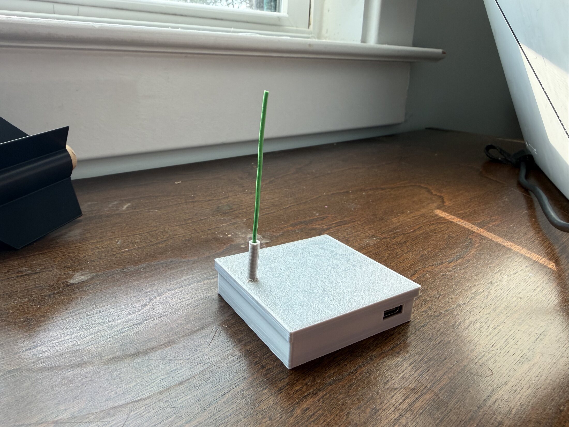 Grey 3D-printed ground station enclosure with vertical antenna